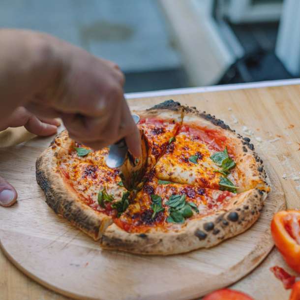 Gezellig samenzijn rondom een buiten pizza oven tijdens een zomeravond