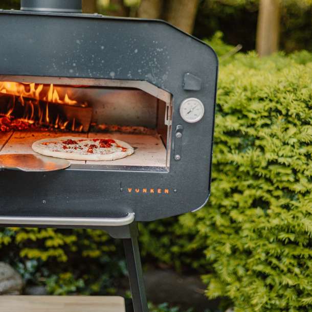 Moderne pizza oven in een sfeervolle tuinsetting met houten elementen