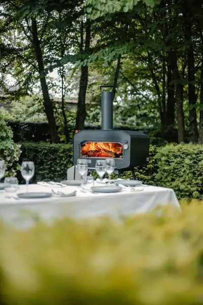 Rustieke pizza oven in een groene tuin, klaar voor gebruik