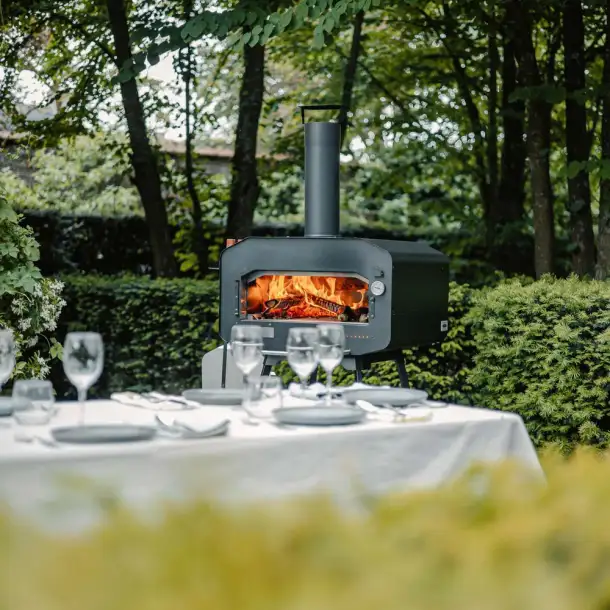 Close-up van een traditionele houtgestookte pizza oven met brandend hout