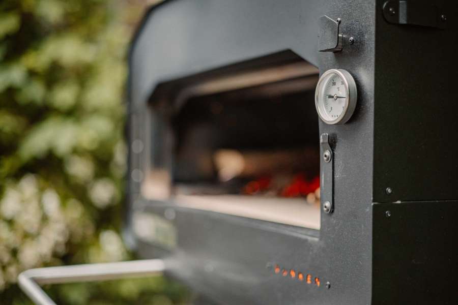 Close up van een houtgestookte pizza oven met gloeiende kolen.