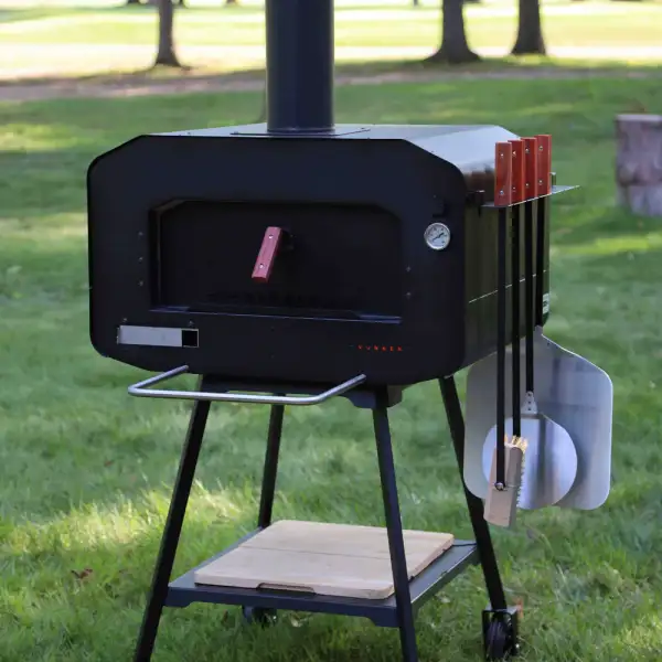 Houtgestookte pizza oven in een groene tuin, klaar voor gebruik