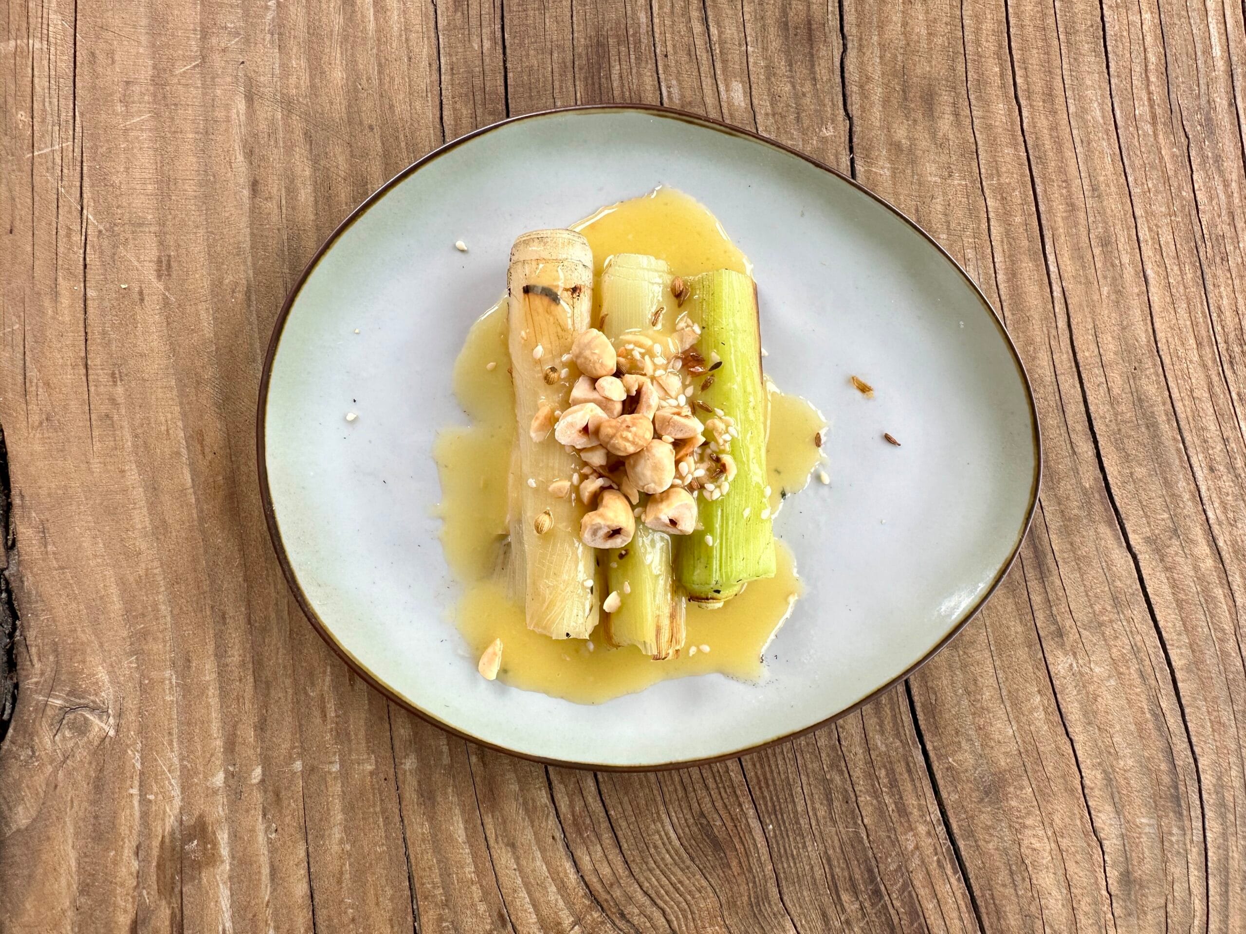 Prei uit de kolen met miso-beurre blanc en dukkah
