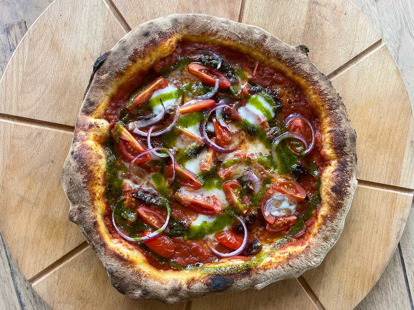 Pizza met rode ui, cherrytomaatjes en basilicumolie