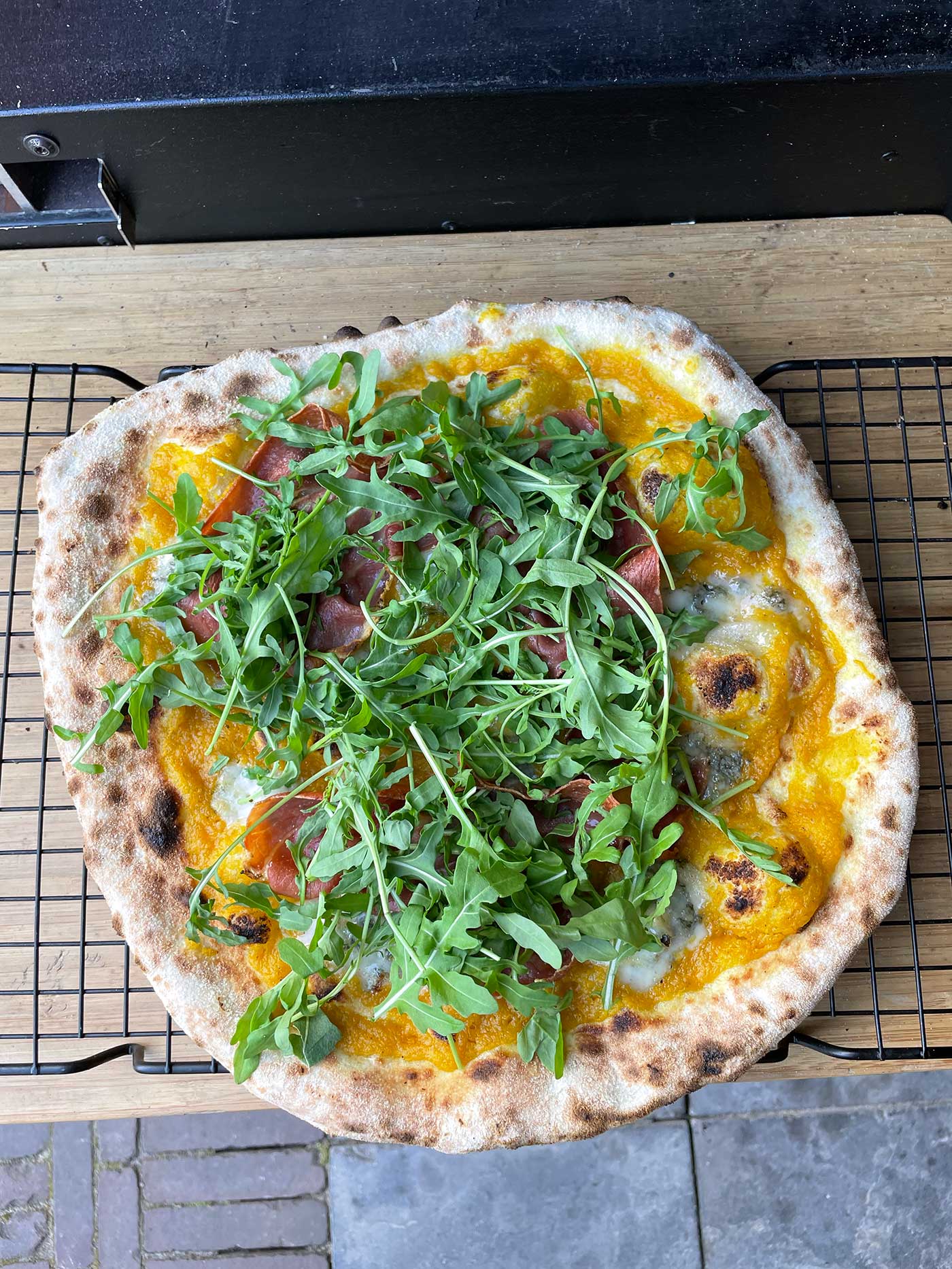 Pizza met pompoencrème, speck en gorgonzola