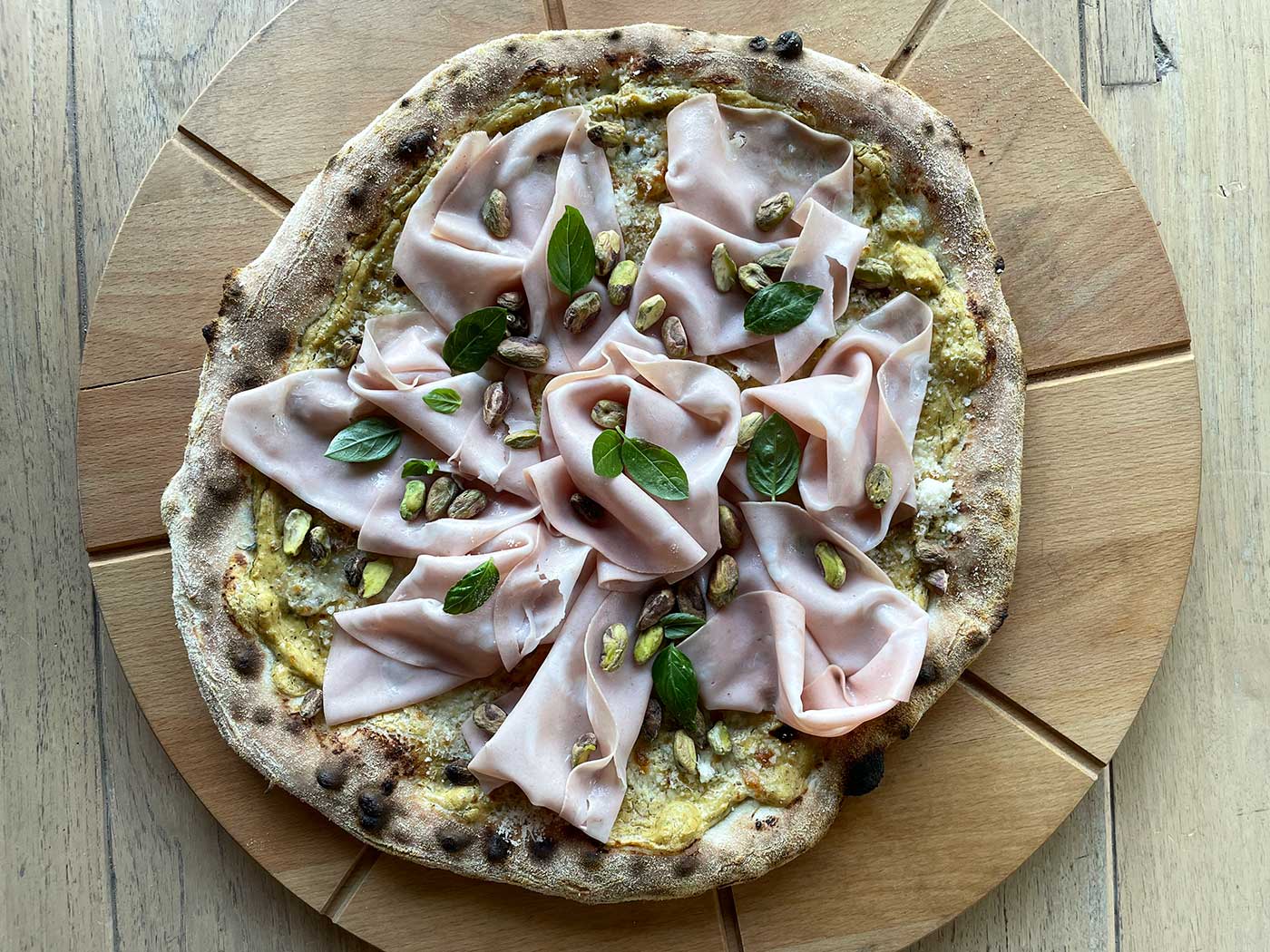 Pizza met mortadella, pistachepesto en stracciatella