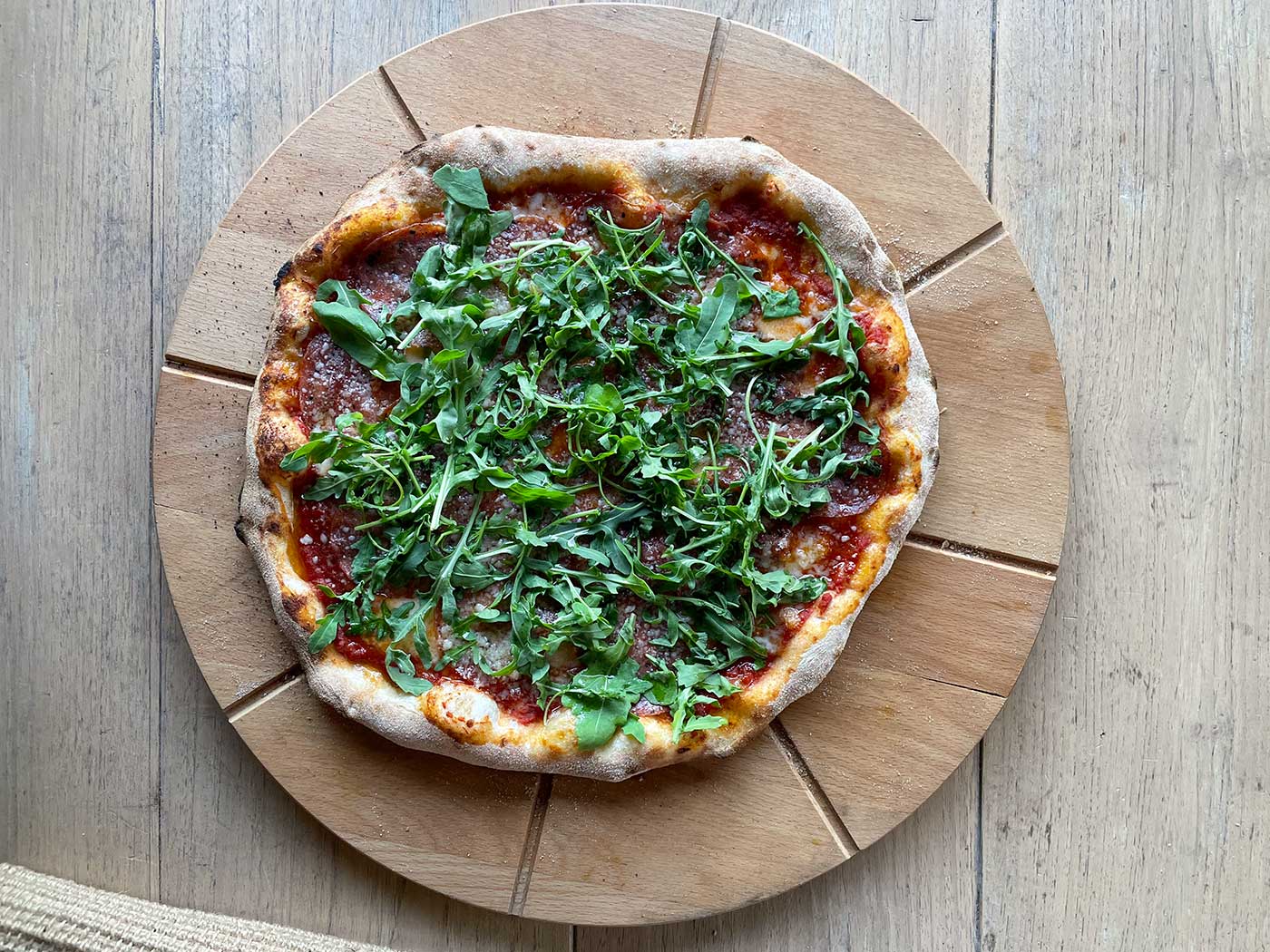Pizza met pittige salami en rucola