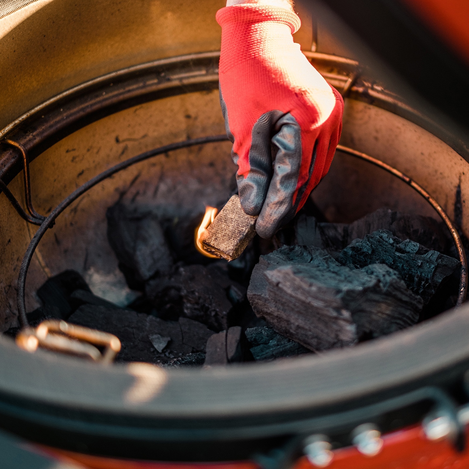 Houtskool in een kamado bbq wordt aangestoken met een aanmaakblokje