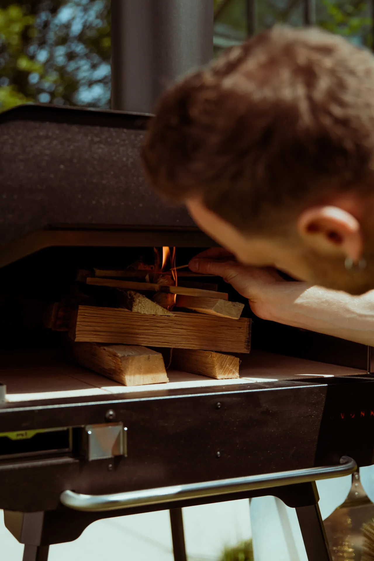 Het aansteken van een houtgestookte pizza oven in de tuin