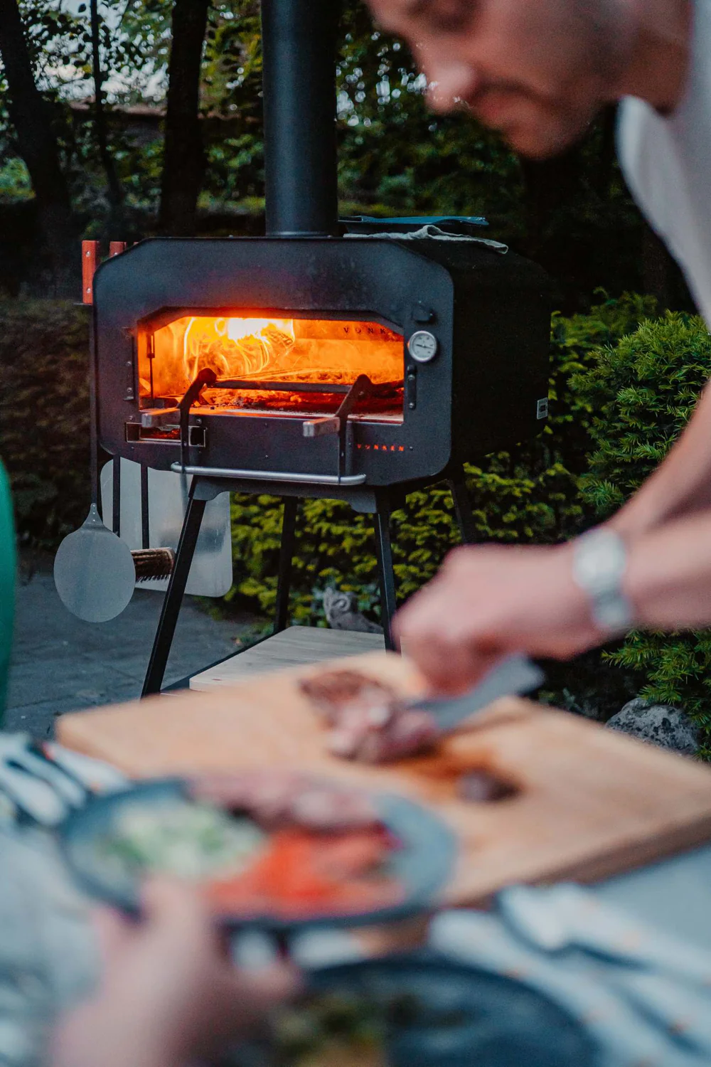 Vonken houtgestookte pizza oven in gebruik met op de voorgrond voorbereiding voor een heerlijke pizza