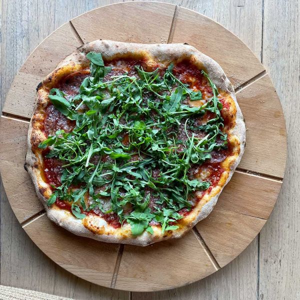 Pizza met pittige salami en rucola