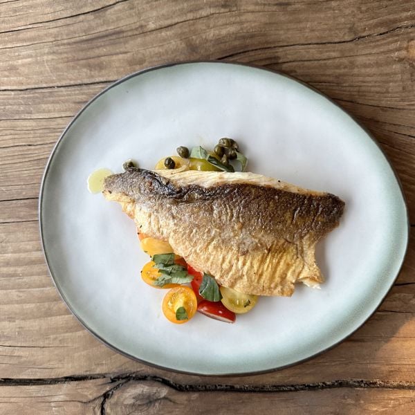Krokante zeebaars met lauwe tomaten, ansjovis en kappertjes