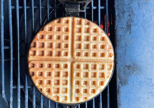 Wafel bakken in gietijzeren wafelijzer op de kamado