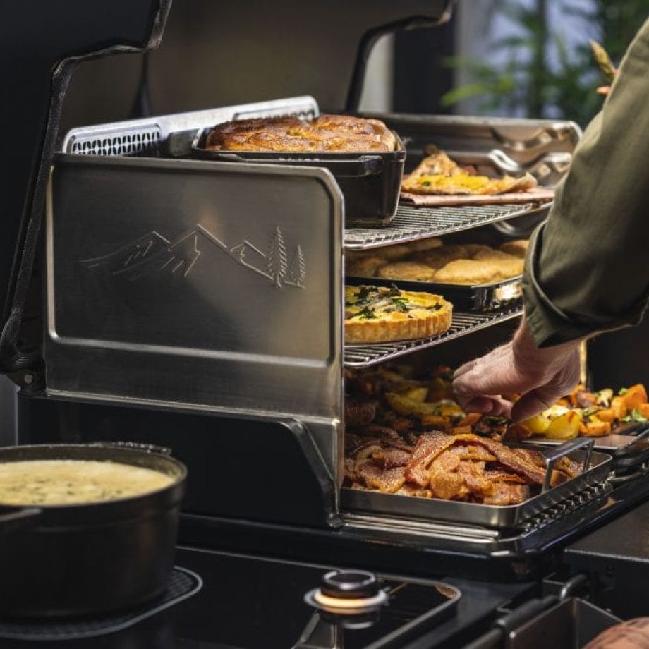 De Traeger Induction kookplaat zit standaard aan de zijkant. Je kookt er direct naast je pellet grill op — sauteren, sauzen maken, bijgerechten bereiden. Geen apart fornuis of gasbrander nodig.