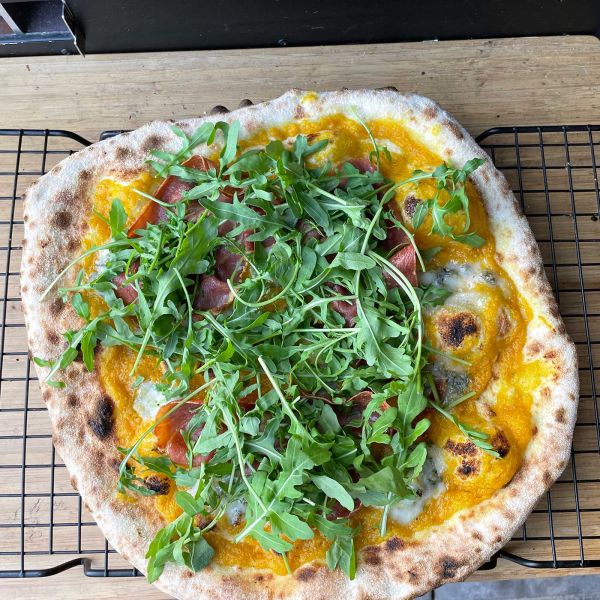Pizza met pompoencrème, speck en gorgonzola