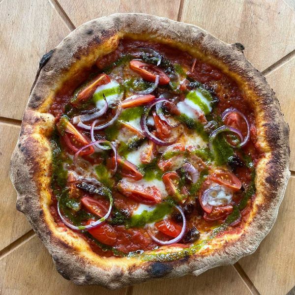 Pizza met rode ui, cherrytomaatjes en basilicumolie